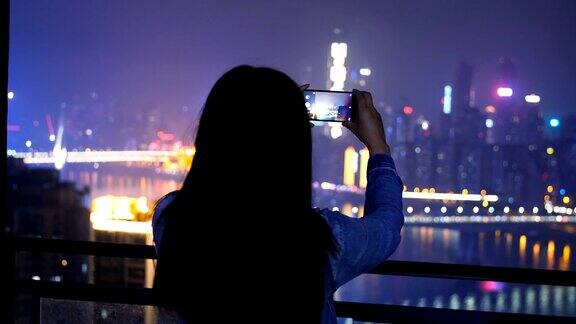 年轻女子正在拍摄城市夜景