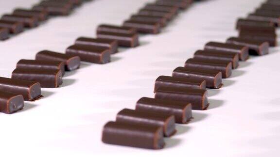 现成的巧克力糖果正在糖果工厂的生产线上移动