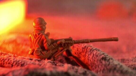 一个玩具塑料士兵机枪手在一个假想的战壕里闪烁着红灯在战场上夜间射击