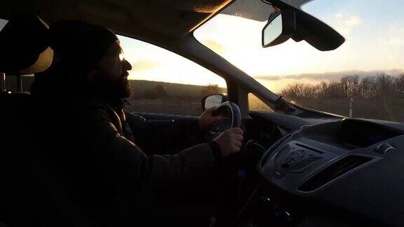 还装有时间流逝司机一个英俊的年轻人开着一辆车车上装有GoPro相机拍摄在日落时分开车