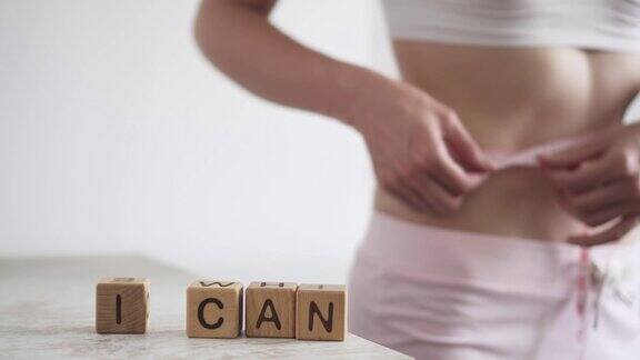 这个女孩在“我能”这个字旁边量了量她的腰围我可以减肥减肥饮食