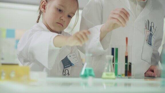 孩子们在做科学实验实验室内部用移液管灌注多种颜色的液体近距离接触