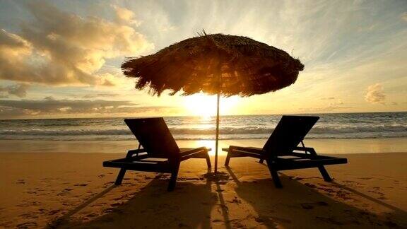 日出的热带海滩与椅子和小屋