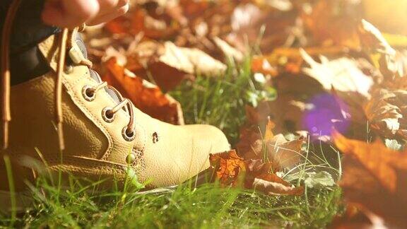 在一个美丽的秋日下午男孩正在系鞋带