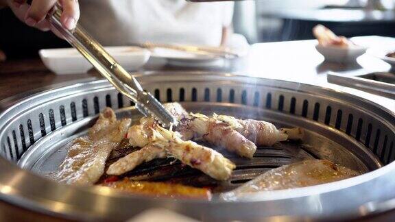 特写一个女人的手烤猪肉烧烤韩国食物