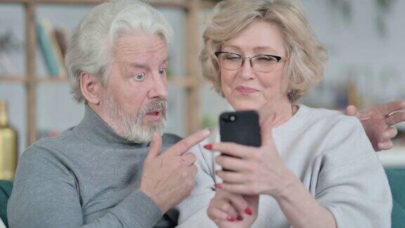 坐在一起使用智能手机的老夫妇
