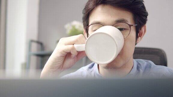 看笔记本电脑屏幕心情愉快早上在家工作的时候喝着咖啡