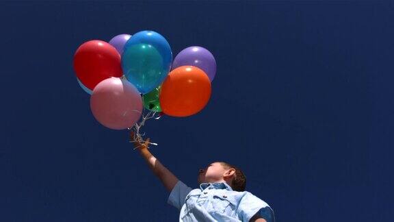 小男孩让气球飞向天空慢镜头