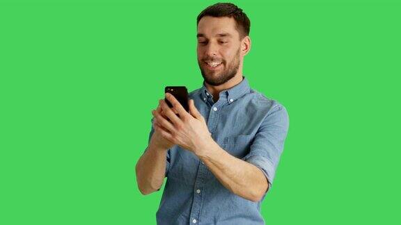 中景的一个时尚的男人做视频电话和显示指向他身后的景点拍摄在绿色屏幕背景