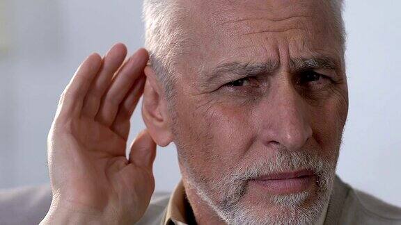 老年男性把手放在耳朵上听力障碍耳聋近景