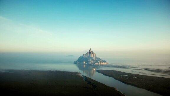 大气电影航拍的雾蒙蒙的日出圣米歇尔山在涨潮在诺曼底著名的岛屿要塞