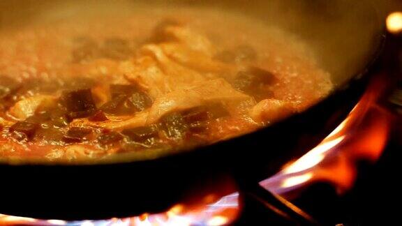 餐厅厨房的厨师在炉子上用平底锅准备鸡胸肉