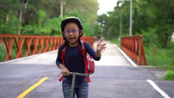 慢动作回到学校亚洲小女孩背着书包骑着滑板车去上学