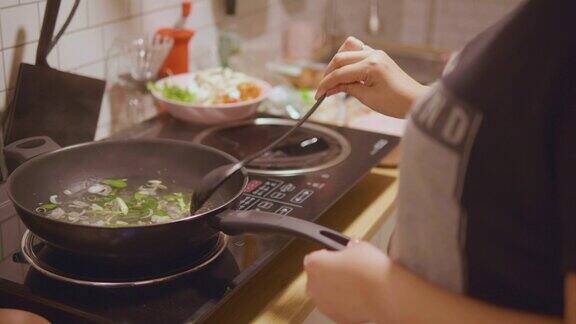 亚洲妇女在家里做东百胜开泰国菜