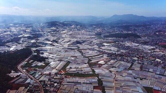 无人机在巨大的乙烯基温室建筑上空飞行室内有机农业温室的鸟瞰图