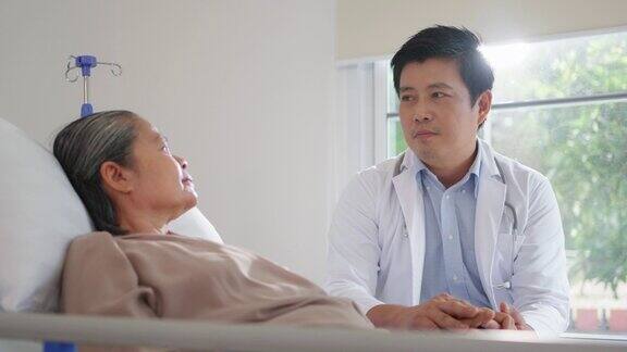 专业的亚洲医生牵着躺在养老院床上的老年妇女的手照顾者提供照顾医疗服务帮助支持微笑的老奶奶在家照顾医疗