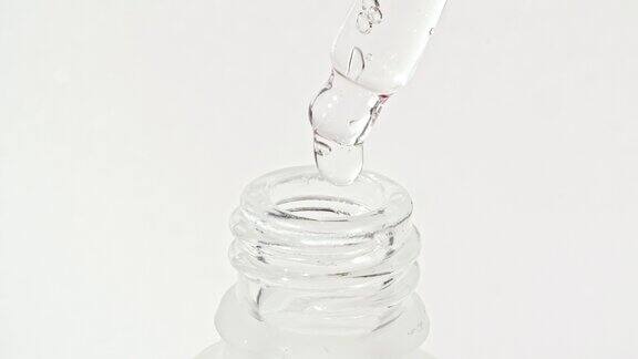 透明的化妆品凝胶液在移液管中滴入瓶中天然有机化妆品医药生产特写慢动作