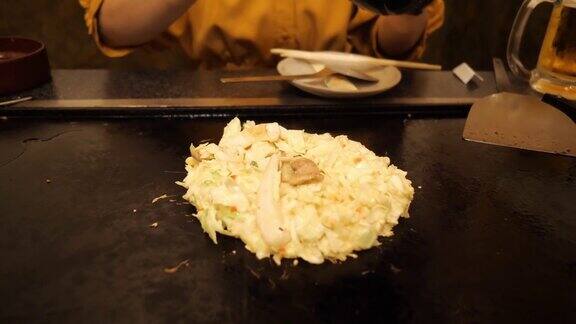 在日式餐厅里年轻女子在煎锅上做御膳烧