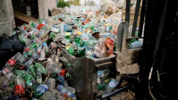 铲车移动一堆塑料瓶在一家回收工厂工作