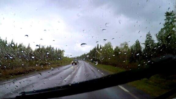 从雨中看汽车在潮湿的道路上行驶在挪威的路上驾驶汽车