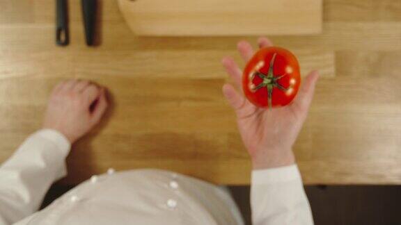 慢动作:厨师抛出西红柿并抓住它-俯视图