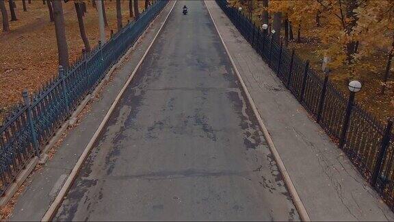 秋天的路在公园骑摩托车的人在高速公路上行驶俯视图从直升机