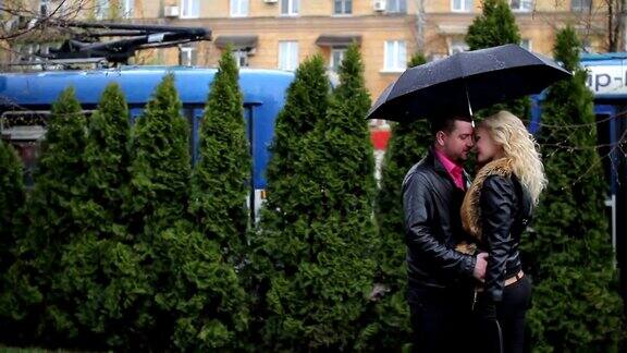 一对情侣撑着雨伞在雨中