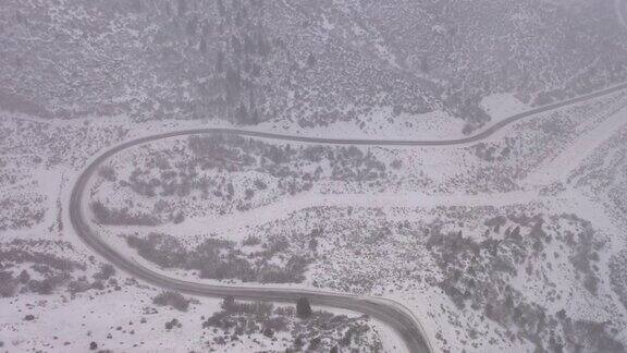 在冬季暴风雪中飞过蜿蜒的山路