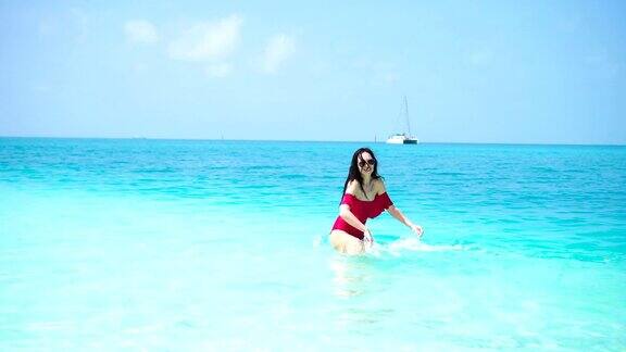 海滩上的年轻美女快乐的女孩享受她的热带度假异国岛屿