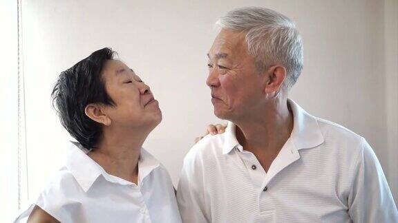 幸福的亚洲老年夫妇在白色的背景笑和说话