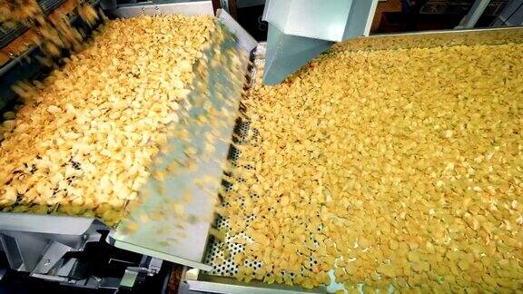 大量的薯片正沿着传送带移动薯片生产