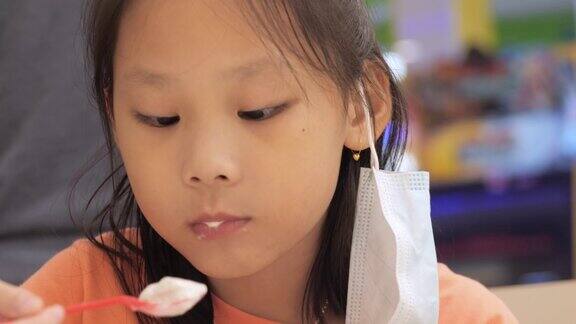 亚洲女孩吃冰淇淋在美食广场与家人生活方式在周末