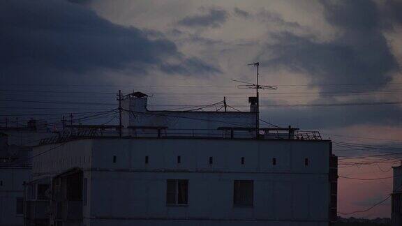 托洛伊茨克市屋顶上空移动的云时间在暮色中流逝特写镜头
