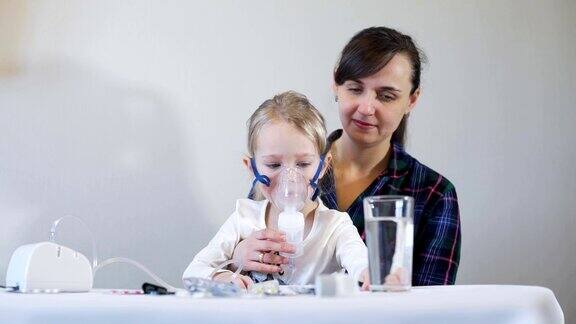 小女孩和母亲用喷雾器吸入