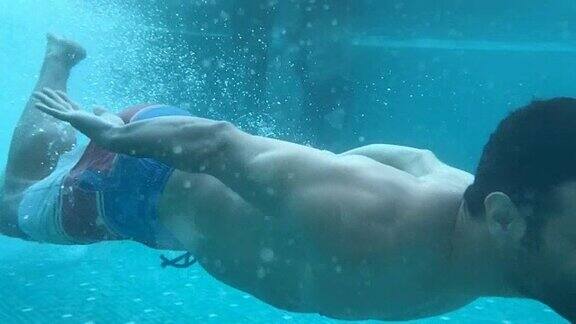 帅气的人潜入游泳池游泳的慢动作