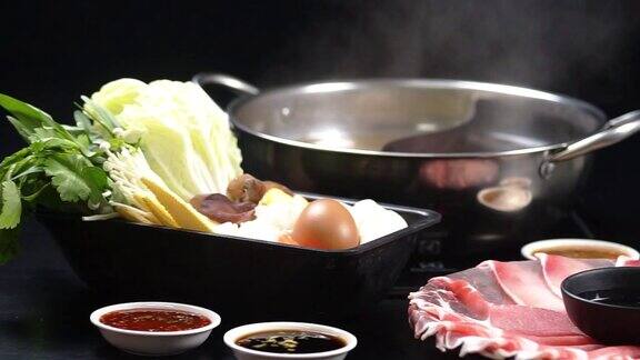 2片生猪肉切片装盘以及日式火锅中的各种食材