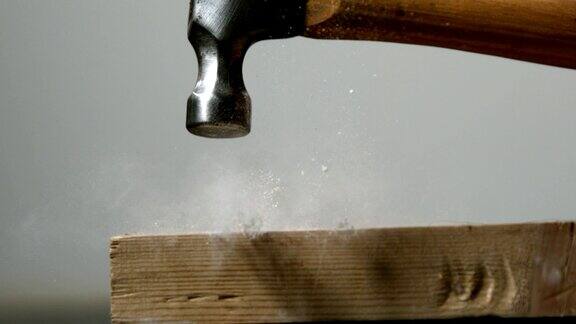 慢镜头锤子把钉子敲进木板