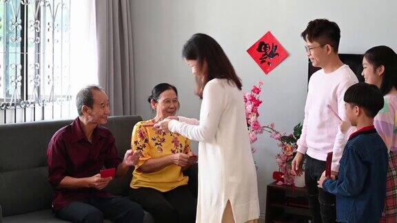 中国农历新年的第一天亚洲老人在家里给他们的孩子和孙子孙女发红包
