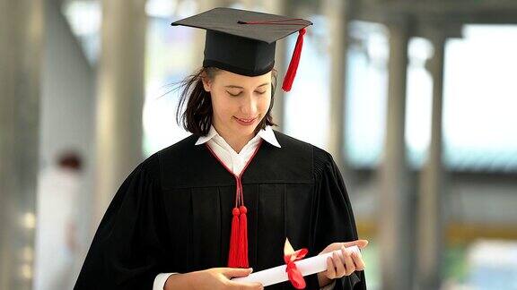 美丽的微笑毕业的学生女孩的肖像年轻的女人在帽子长袍行走和拿着文凭