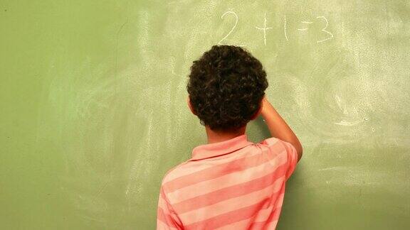可爱的小学生在黑板上写数学