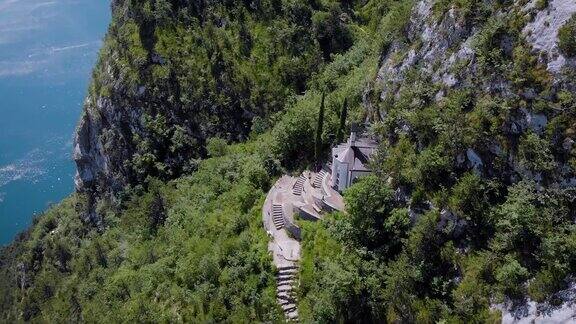 鸟瞰图美丽的落基山脉悬崖上有一座小教堂圣巴巴拉离加尔达里瓦不远的一座教堂