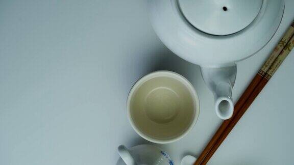 高角度的茶壶与茶杯和筷子