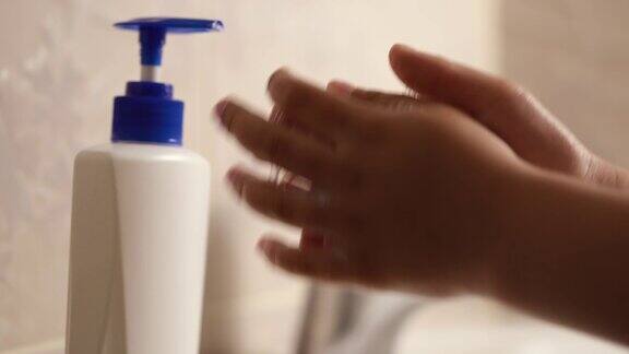 孩子在一个白色的水槽上用肥皂洗手以消除细菌防止冠状病毒感染个人卫生洗手该男孩在covid-19隔离期间洗手