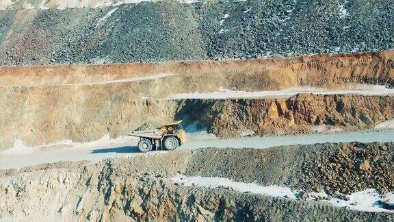 采石场露天采矿矿石提取概念一辆满载货物的卡车正沿着一个露天矿的斜坡行驶