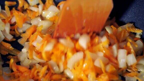 在平底锅里炸蔬菜胡萝卜和洋葱特写