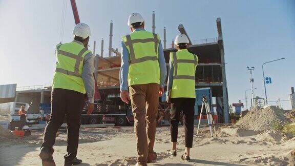 多样化的专家团队检查商业工业建筑施工现场房地产项目与土木工程师投资者和女商人在背景摩天大楼的模板框架