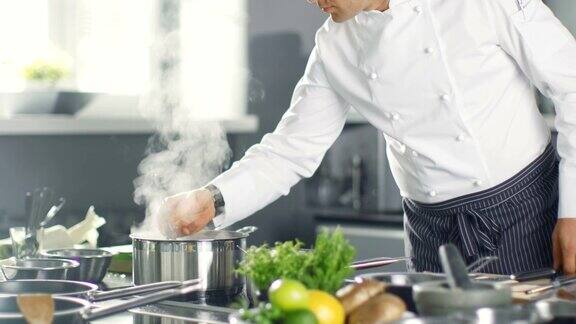 名厨用平底锅搅拌汤或酱汁他在现代厨房里做饭