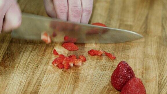 近距离厨师在厨房的砧板上切新鲜的草莓4k