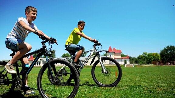 两个朋友一起骑自行车在绿色的草地上
