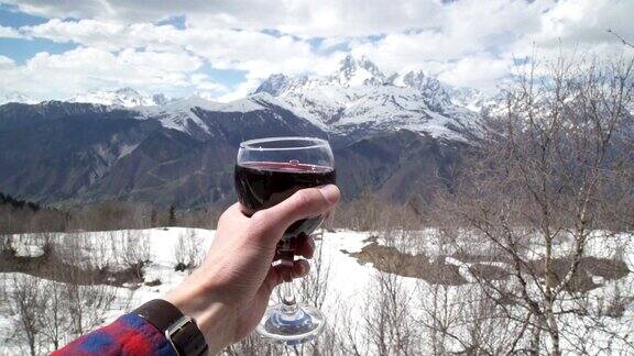雪山前手捧红酒